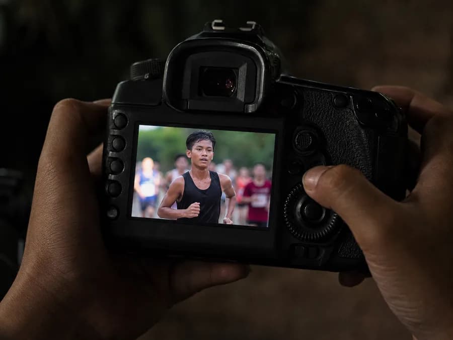 A photographer's camera, its rear screen showing a frame just taken